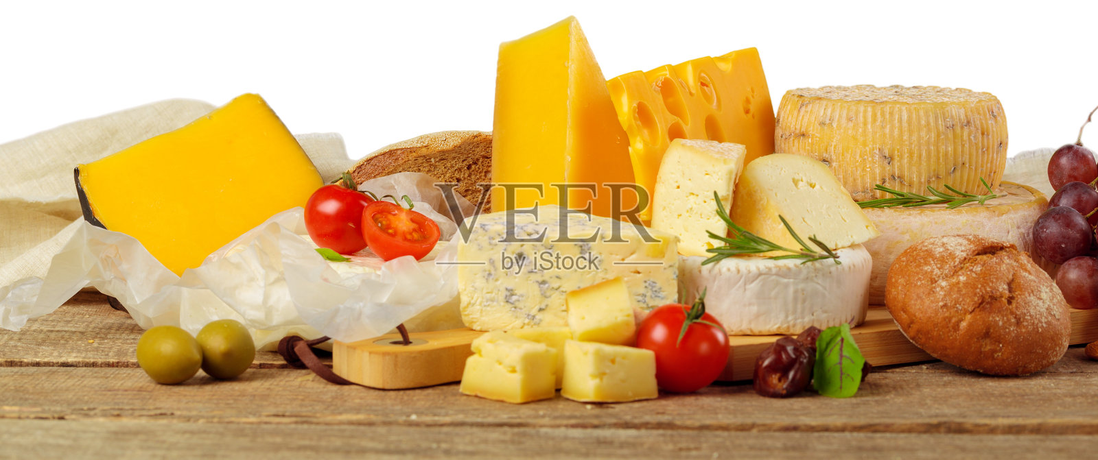 木制桌上的奶酪拼盘，配有新鲜蔬菜和面包照片摄影图片
