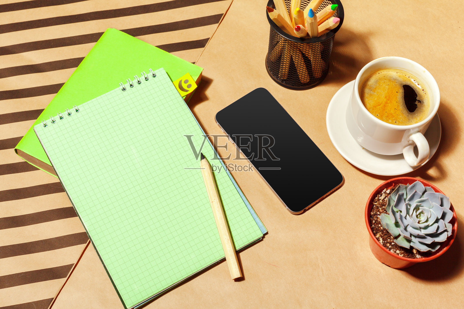 在咖啡馆工作，木桌上放着笔记本、智能手机和植物照片摄影图片