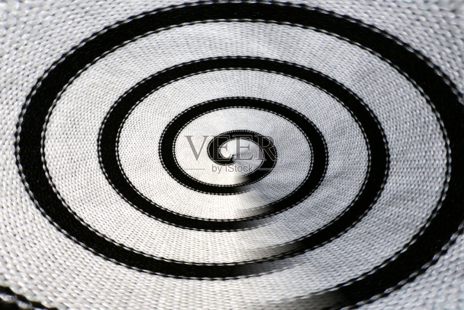 抽象黑白螺旋织物纹理背景，带有同心曲线、编织纺织品细节、光学错觉效果和强烈的对比度，非常适合现代、艺术或概念设计。照片摄影图片