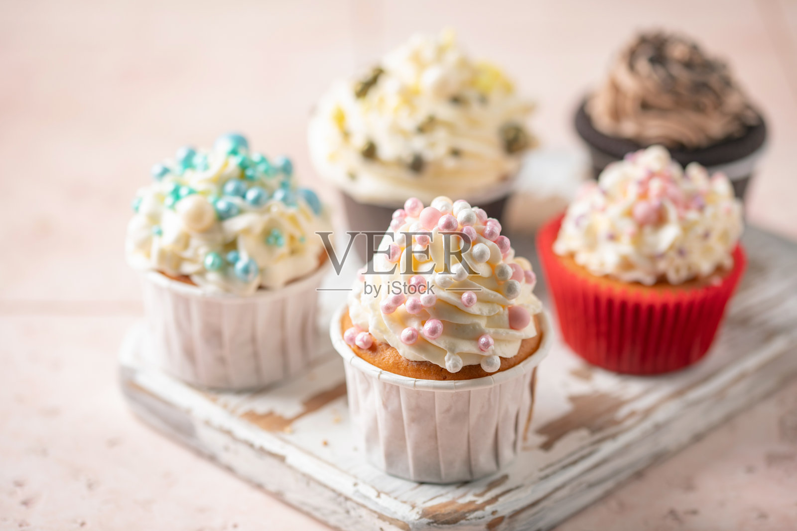 纸杯蛋糕配打发奶油和糕点糖珠照片摄影图片