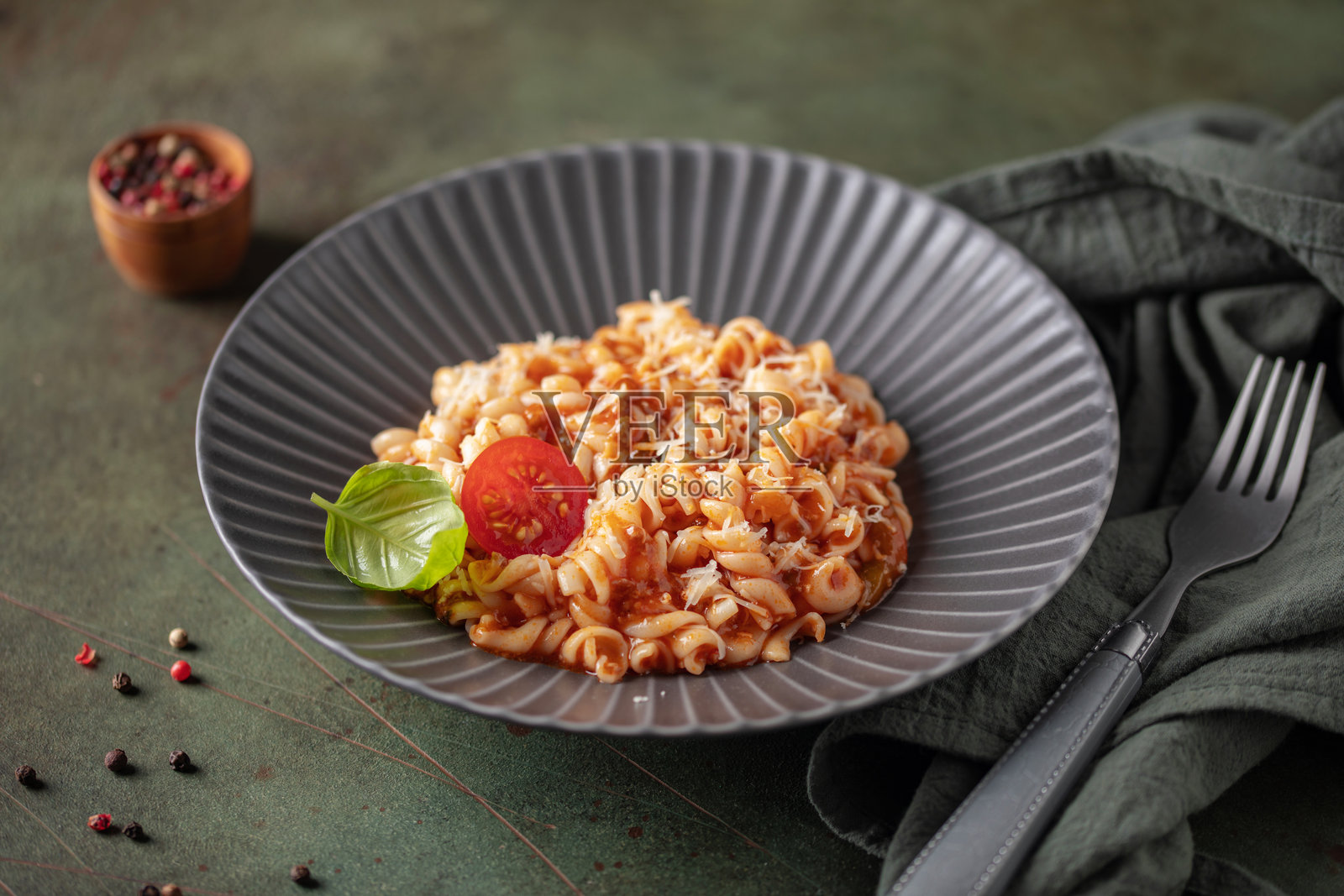 在深色背景的碗中盛放的意大利肉酱螺旋面，这是意大利的流行美食。照片摄影图片