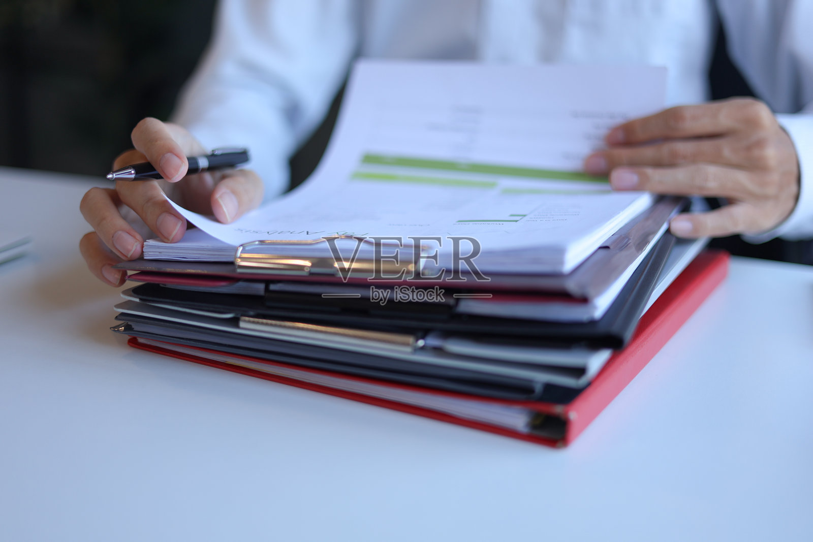 商人正在办公室阅读和签署一叠文件照片摄影图片