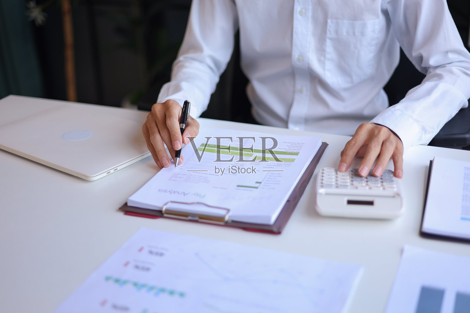 一位商务人士在办公室使用计算器工作照片摄影图片