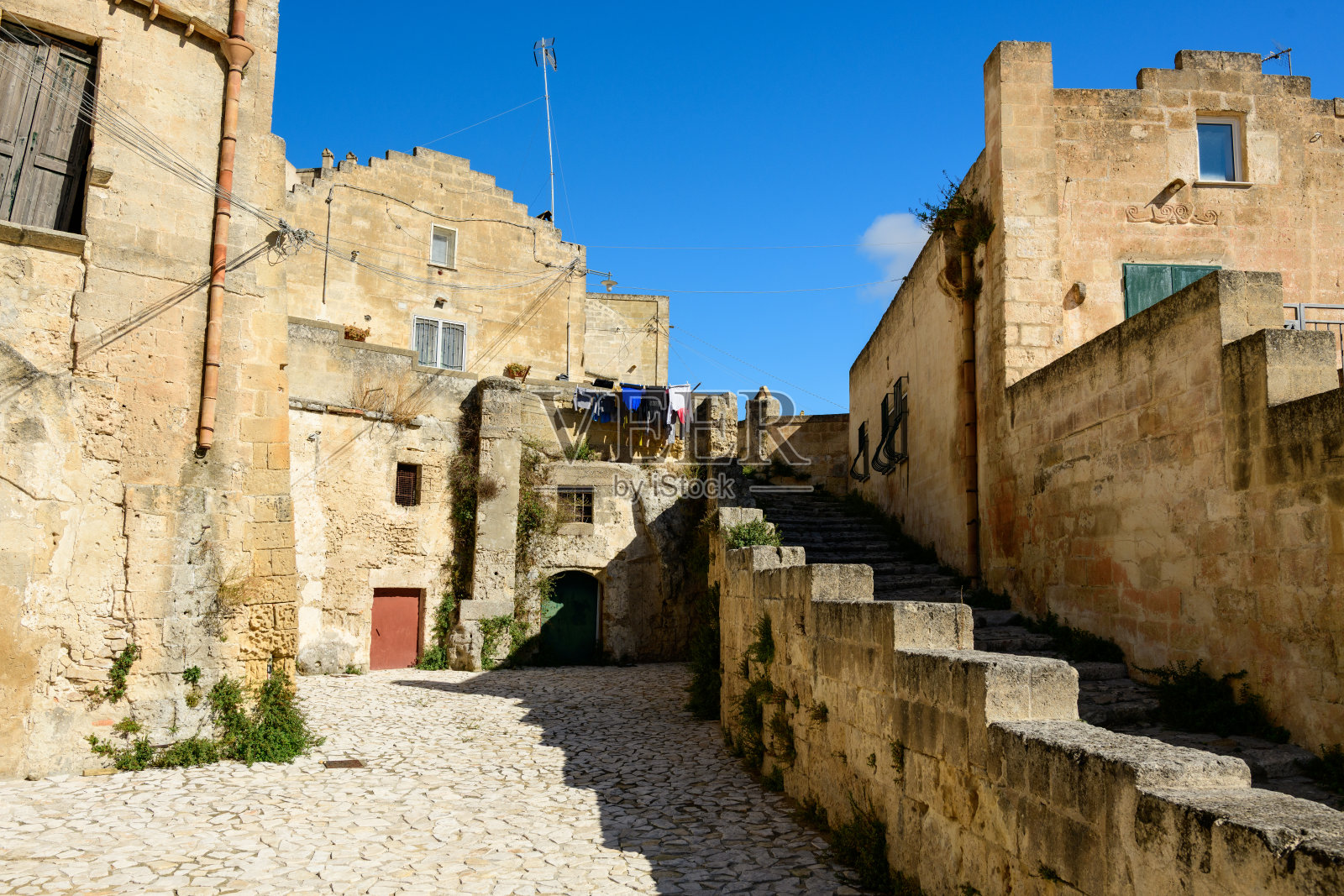 马泰拉，石砌小巷，有楼梯和阳光充足的墙壁照片摄影图片