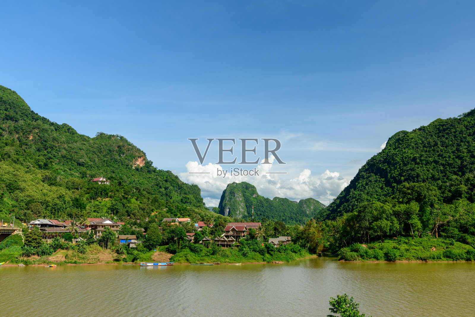 老挝，群山环绕的村庄与河流照片摄影图片