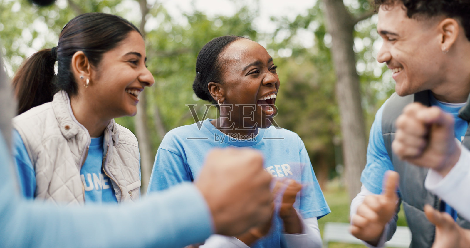 快乐的志愿者们为森林社区服务项目的成功鼓掌，非政府组织圆满完成项目。户外庆祝活动，人们肩负社会责任，参与慈善活动并为成就鼓掌。照片摄影图片