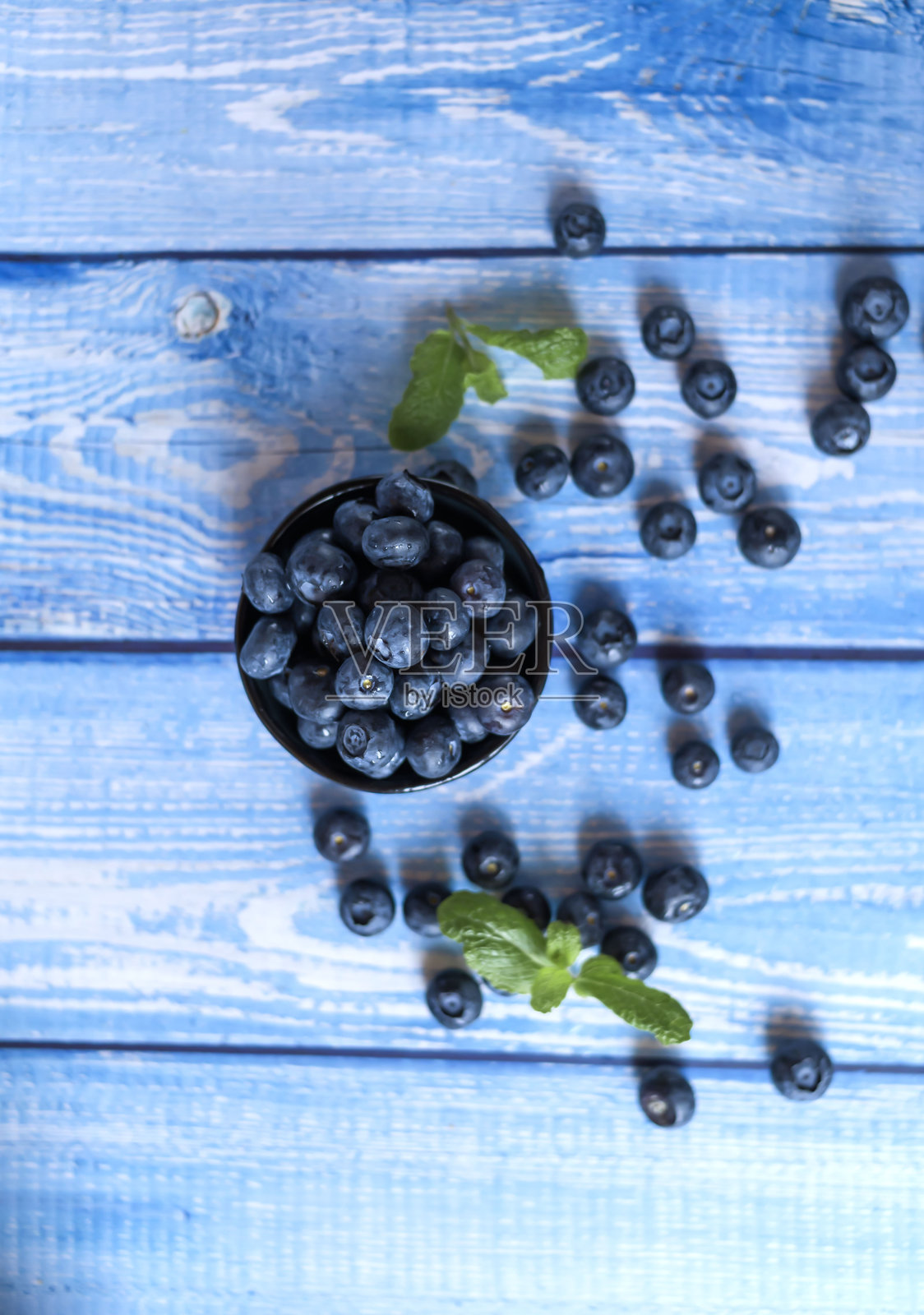 桌子上的蓝莓。蓝色的木质背景。食物照片摄影图片