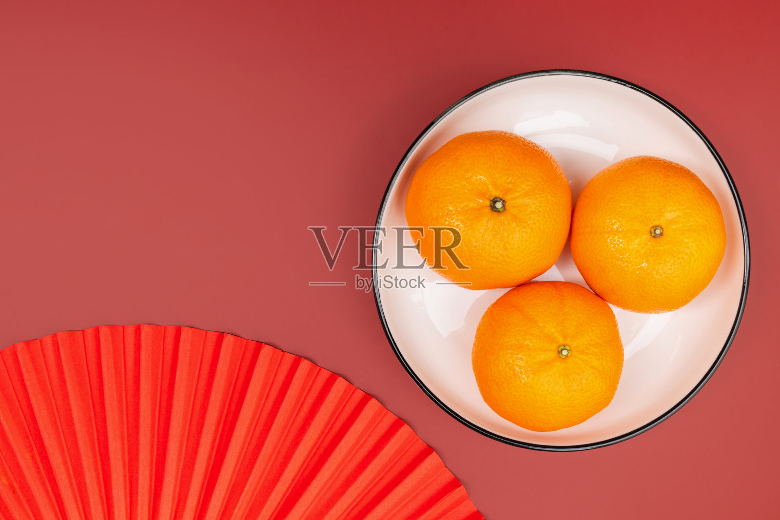 红底白盘上摆放着新鲜橙子，寓意中国农历新年照片摄影图片