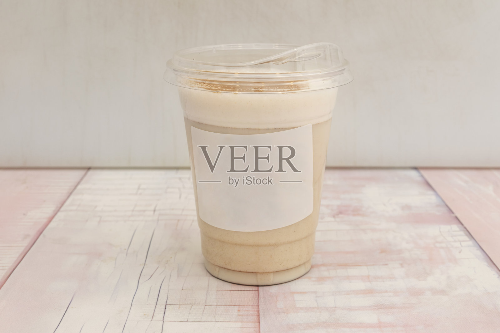 在小巧的瓷杯中盛放的古巴科尔塔多咖啡，杯沿装饰着金黄色的奶泡和焦糖。照片摄影图片