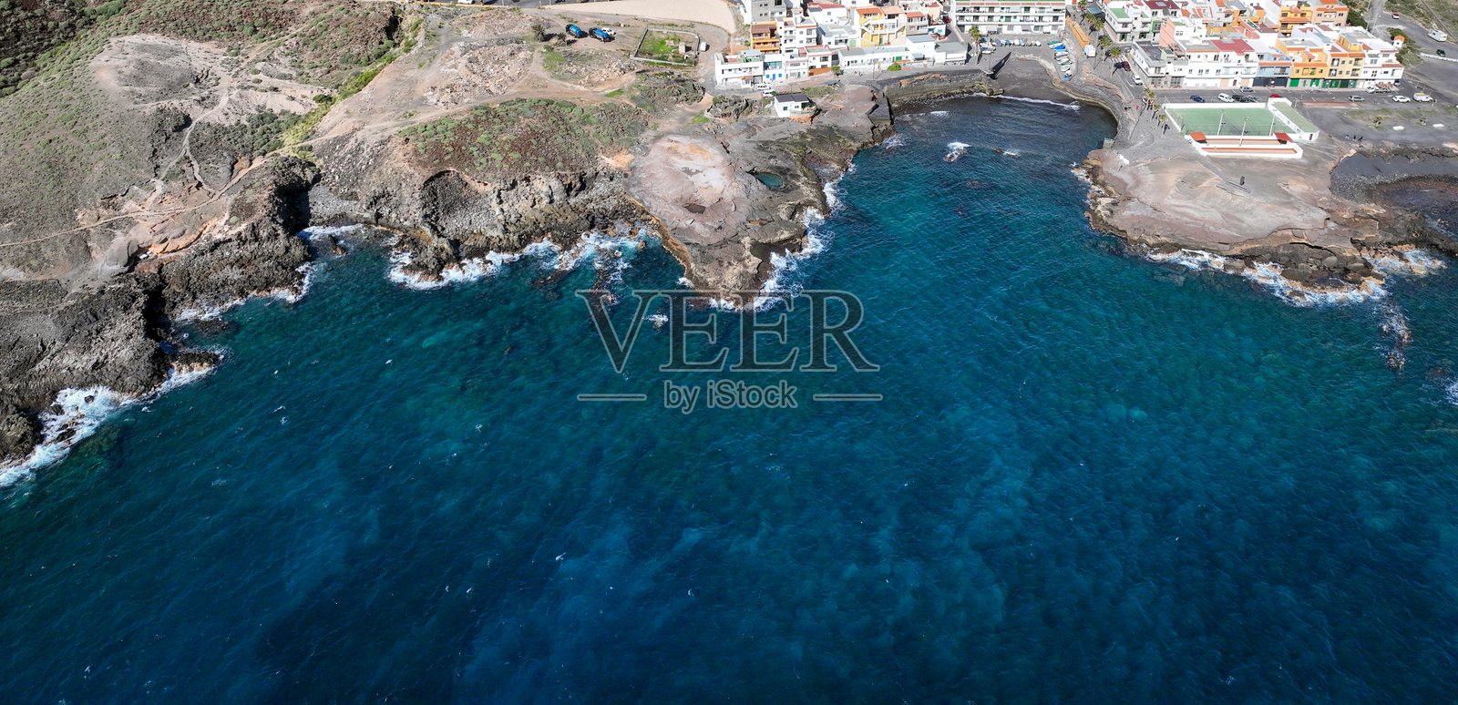 从无人机顶视拍摄的，大西洋沿岸拥有明亮房屋的美丽村庄。照片摄影图片