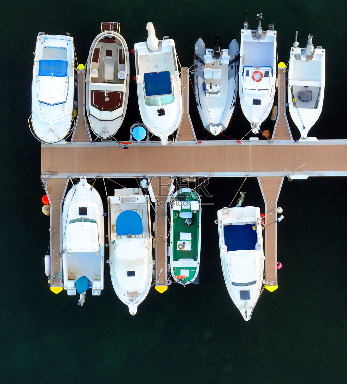 渔船，游艇，深色背景，从上方无人机视角拍摄的包含白色机动船的港湾。照片摄影图片