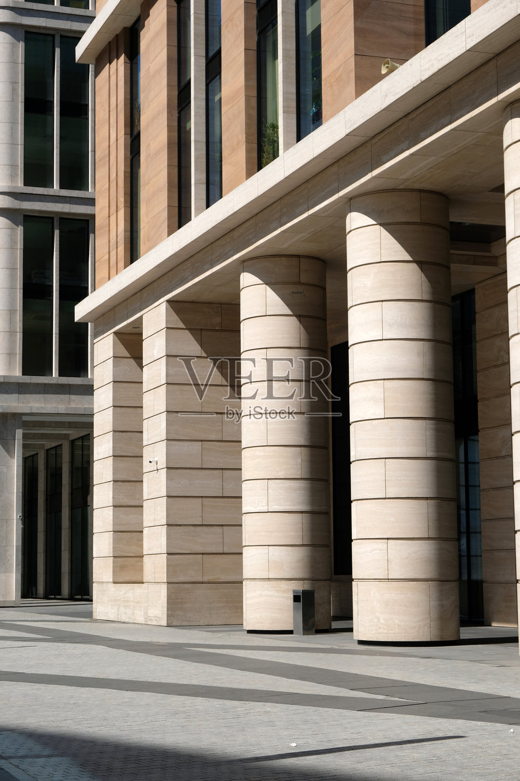 白天城市中带有高耸柱子的现代建筑，展示其建筑设计和结构照片摄影图片