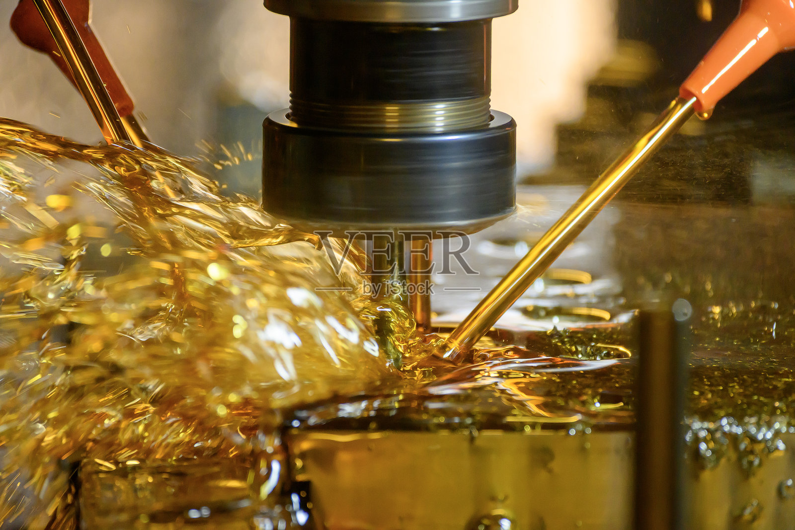 金属加工过程中CNC铣床特写，带有油性冷却剂照片摄影图片