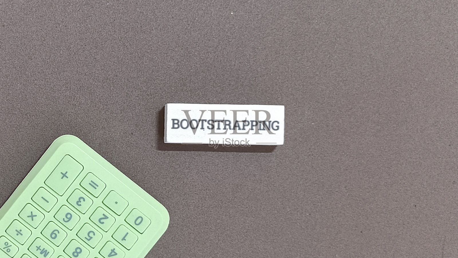 绿色计算器和引导式概念在灰色背景上照片摄影图片