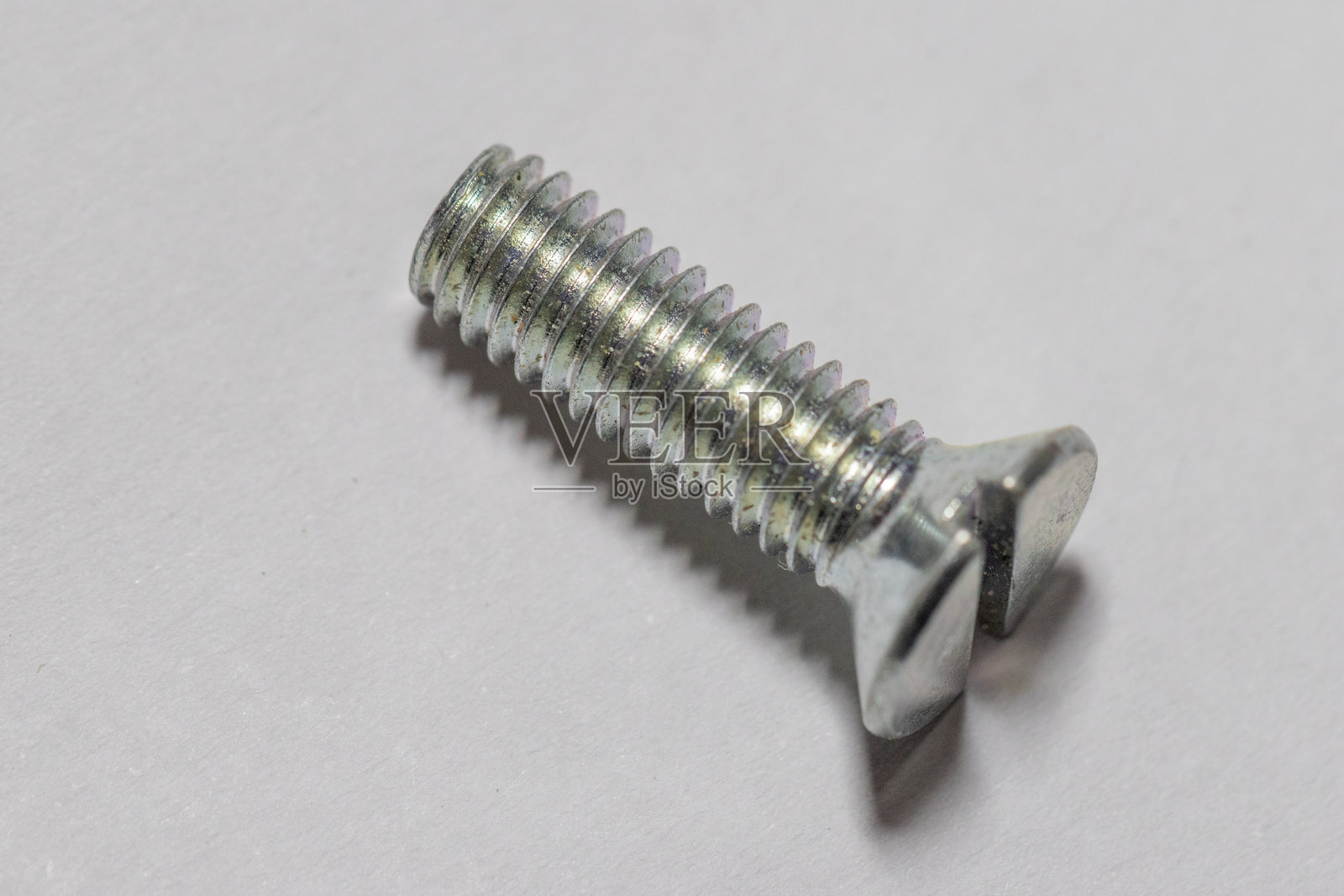 白色背景上的金属一字槽螺钉照片摄影图片