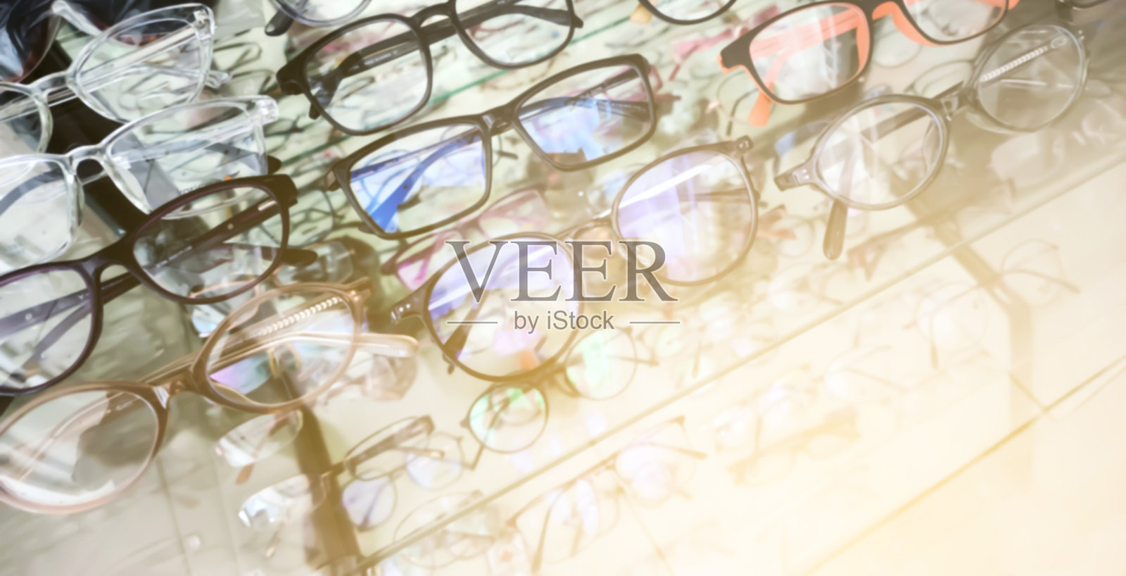 眼镜店橱窗展示的模糊眼镜框，用于背景，玻璃架上展示着各种眼镜框。时尚眼镜，视力护理，零售购物生活方式概念照片摄影图片