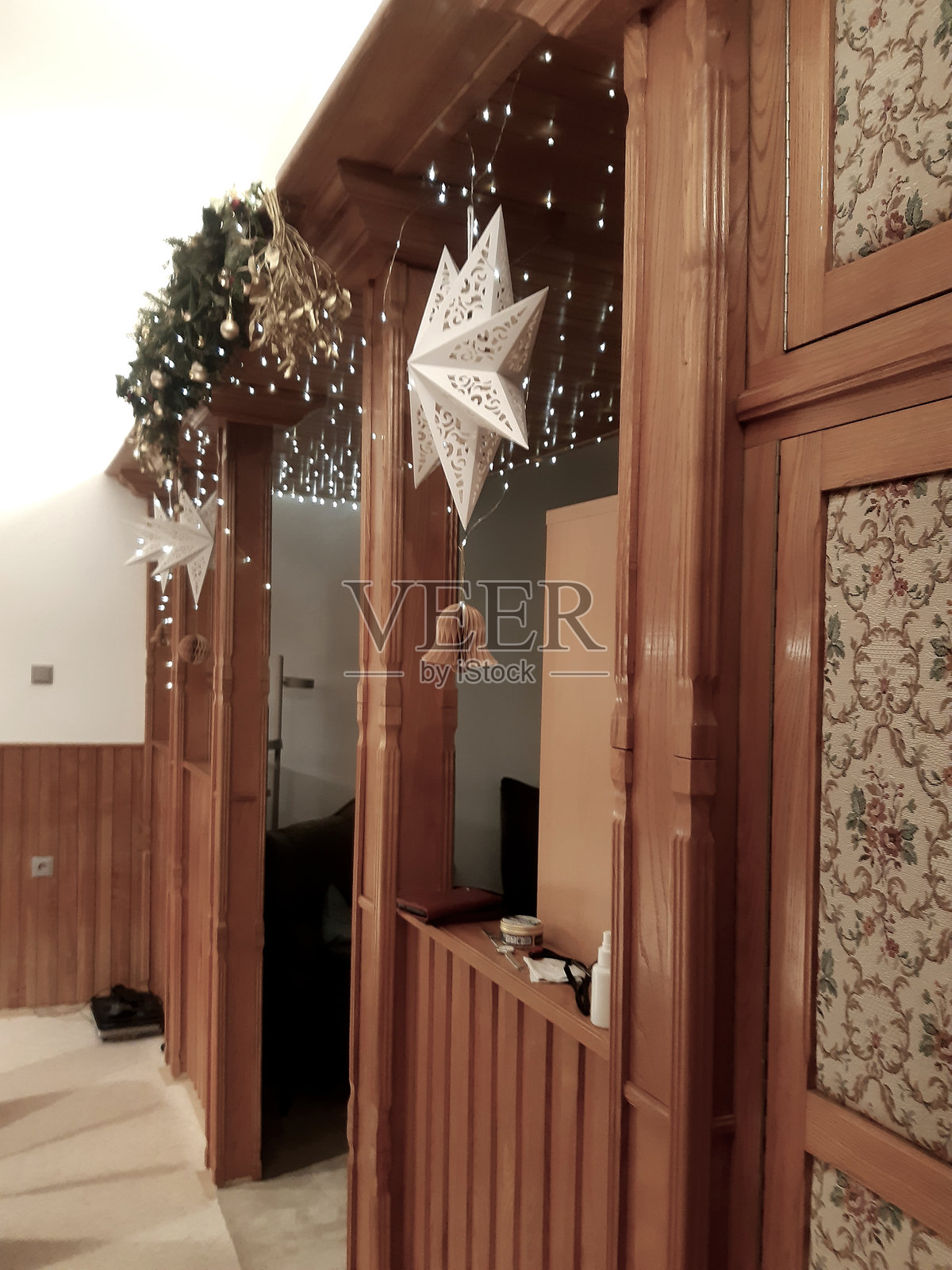 木制结构，重点是深色木制结构，可用作隔断、定制拱门、吧台或餐区壁龛，上方有暖白色串灯天篷照片摄影图片