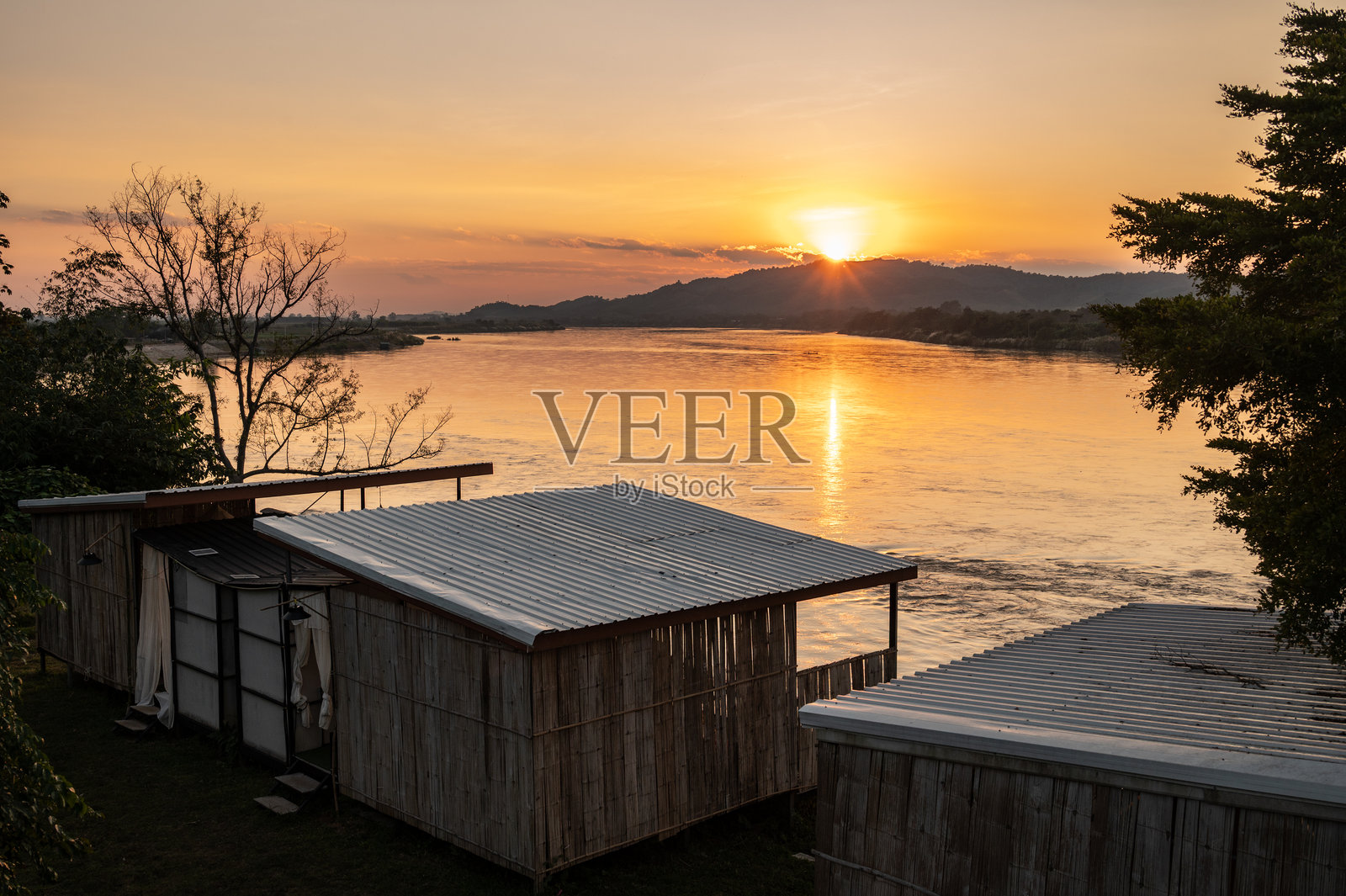 泰国与老挝边境，湄公河对岸的山峦之后，壮丽的日落景象。照片摄影图片