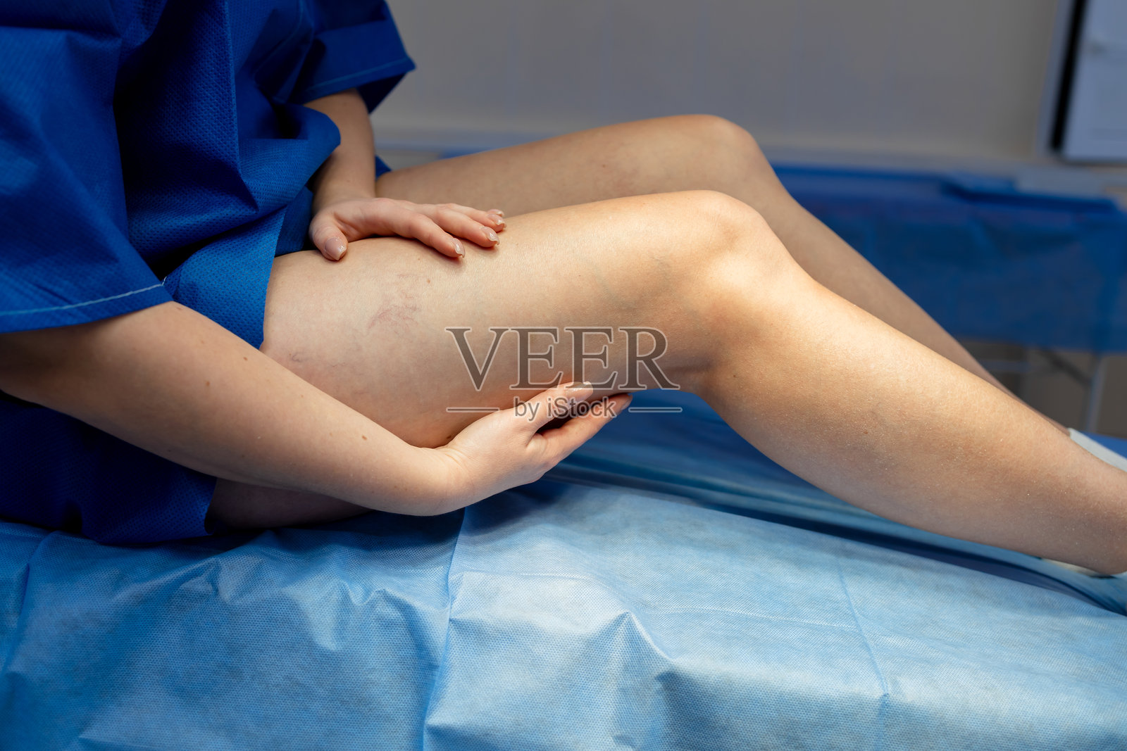 血管腿部检查。轻轻触诊大腿以评估静脉模式。照片摄影图片