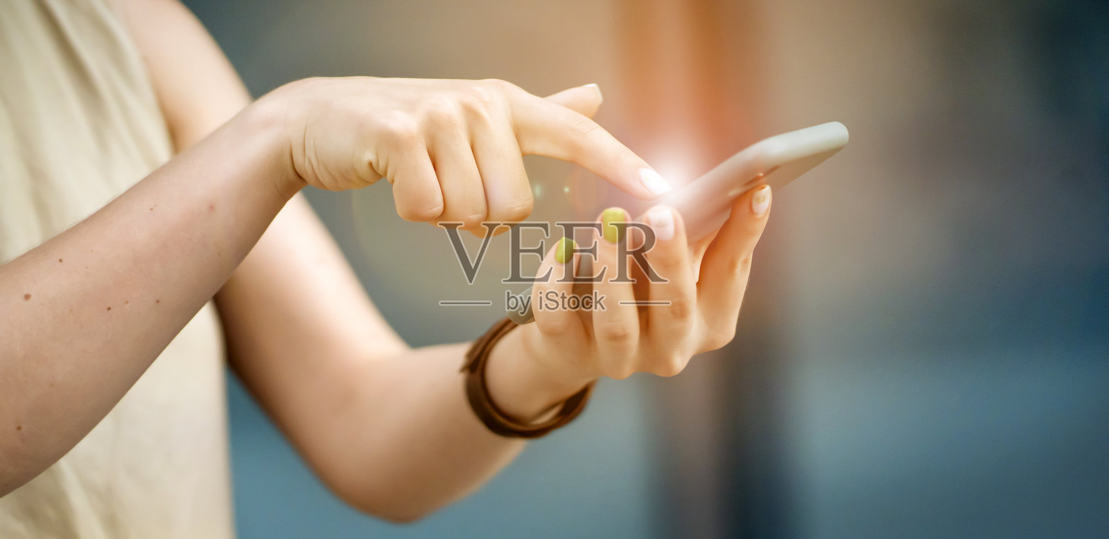 特写镜头：女孩手中拿着一部智能手机。照片摄影图片