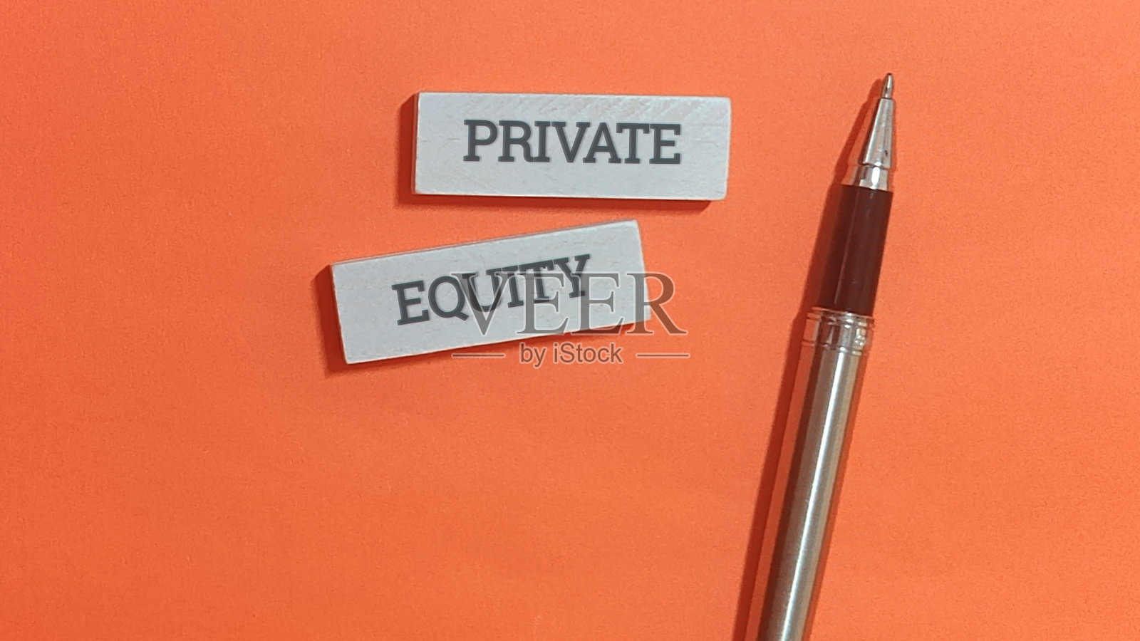 私募股权概念，橙色背景上的钢笔照片摄影图片