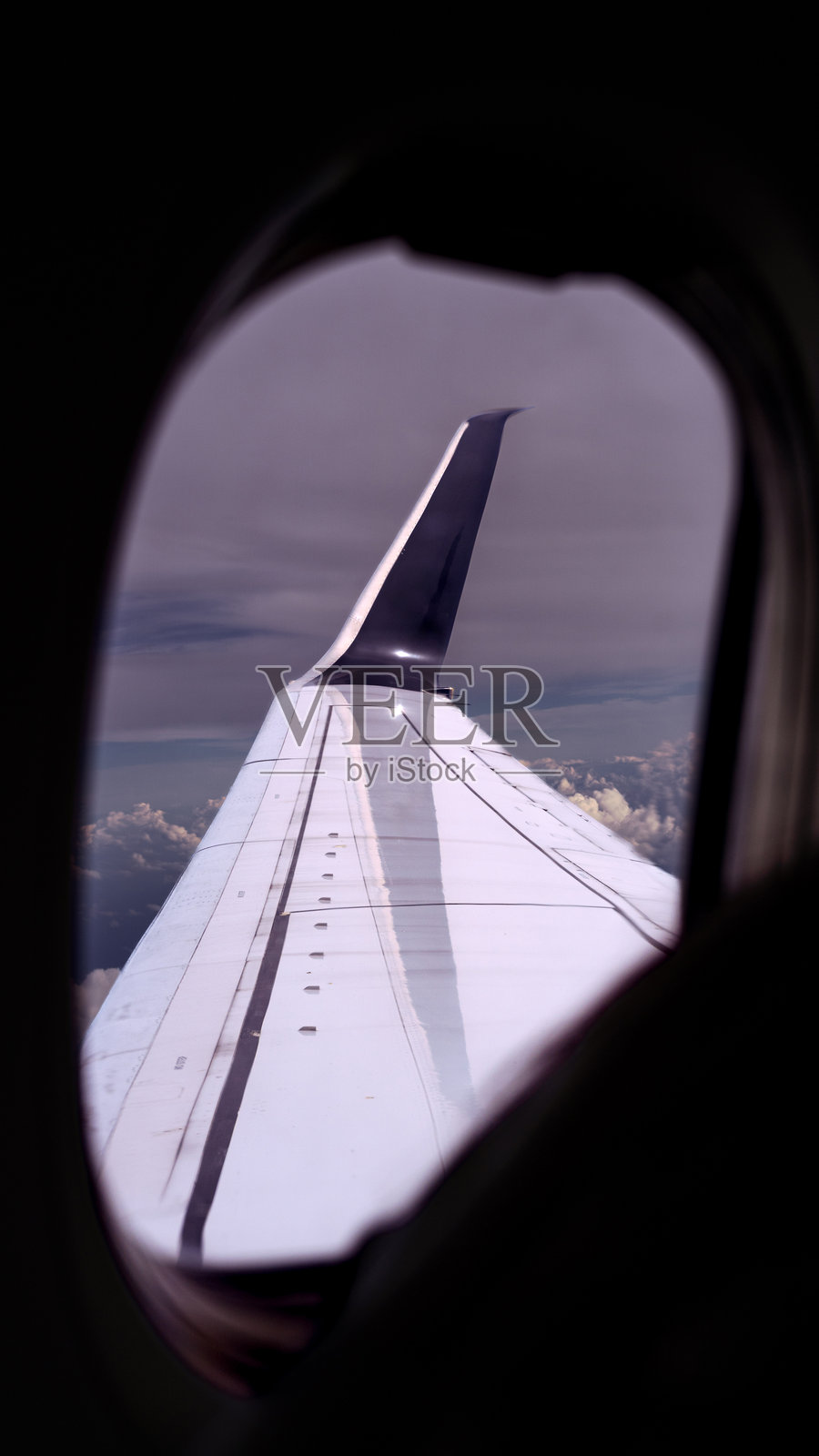 透过窗户看到的飞机机翼，飞越云层之上照片摄影图片