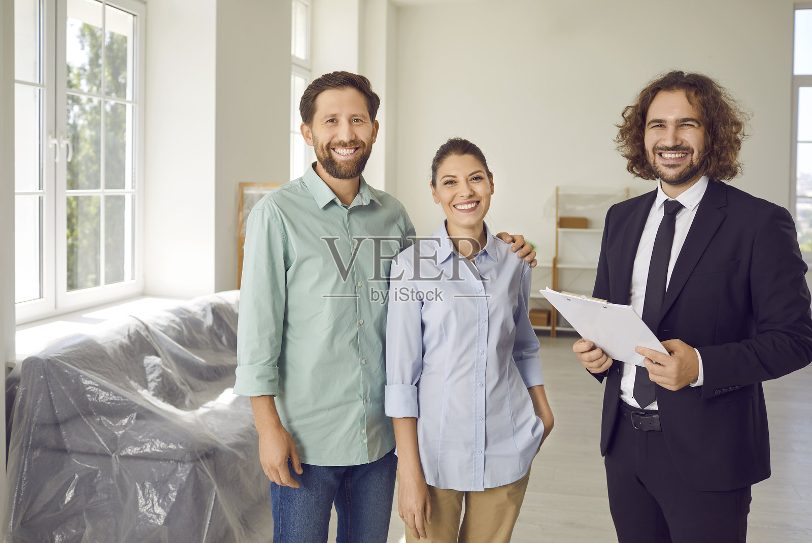 快乐的家庭夫妇与房产经纪人在新房或公寓里的合影照片摄影图片