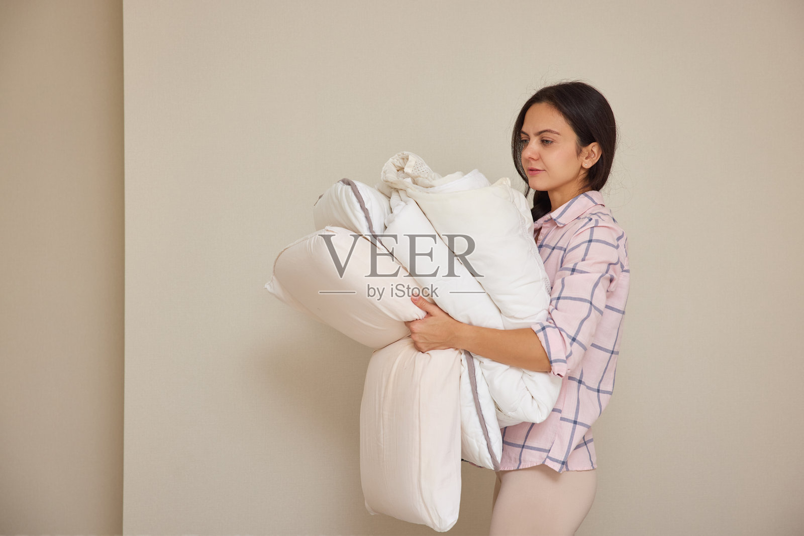 女人在家务劳动中搬运干净的床上用品照片摄影图片