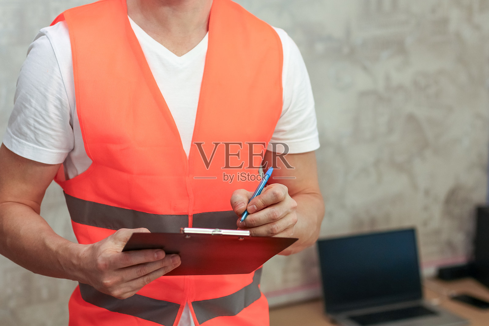 办公室里的工作人员正在用笔在剪贴板上写字照片摄影图片