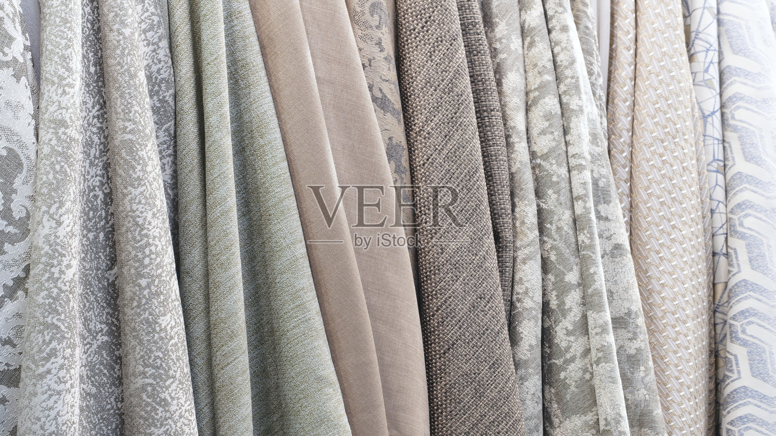 货架上混合着色彩鲜艳的垂直条纹纺织品、织物和布料。特写展示了五颜六色织物的纹理。照片摄影图片