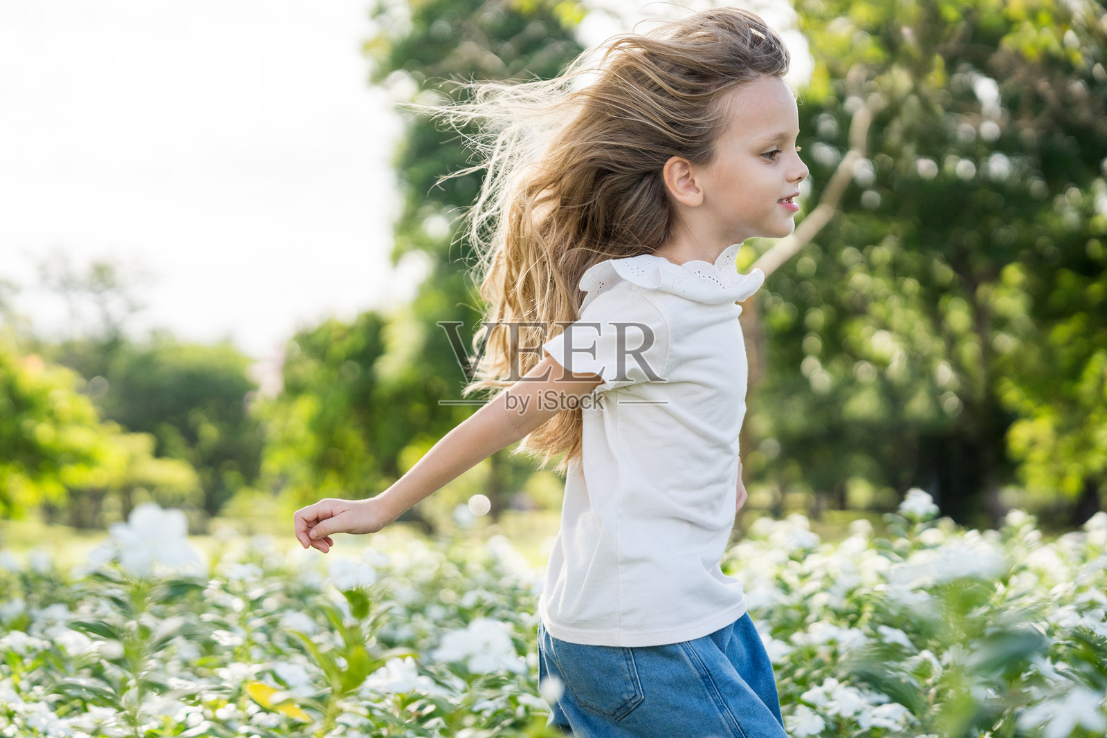 小女孩在晨曦的朝阳中花园玩耍照片摄影图片