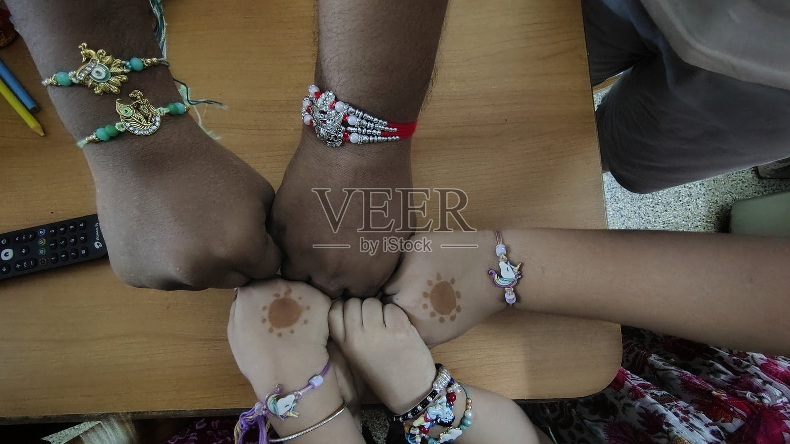 在印度排灯节（Raksha Bandhan）期间，孩子们和一位男子的手中拿着的 Raksha 手链照片摄影图片