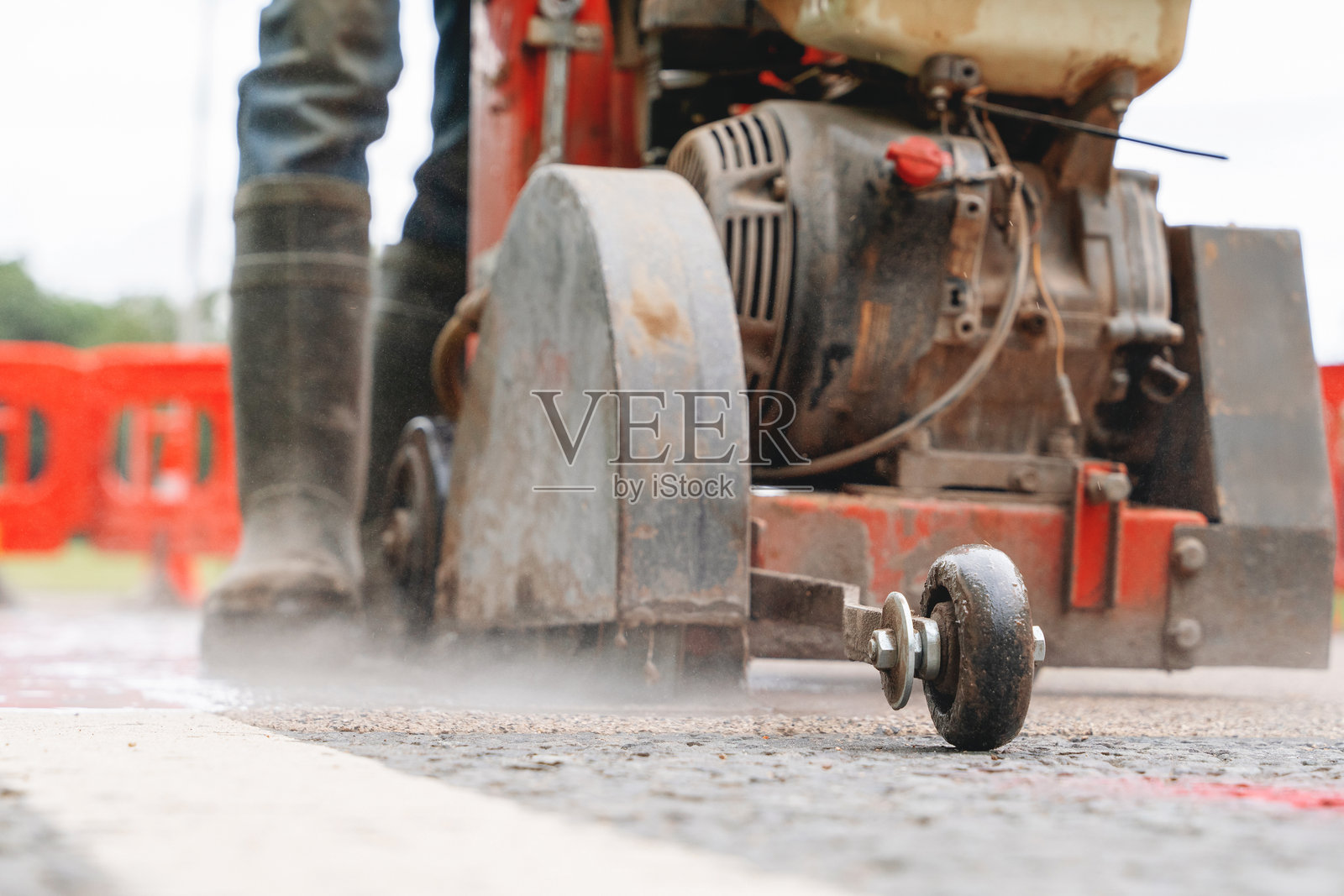 建筑工人使用汽油动力路面切割机和金刚石锯片在道路施工中切割沥青路面照片摄影图片