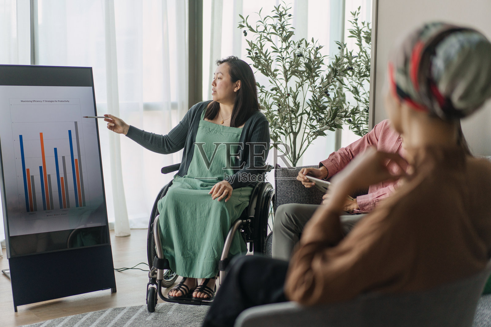 坐在轮椅上的亚洲女性高管主持轻松的小组讨论照片摄影图片