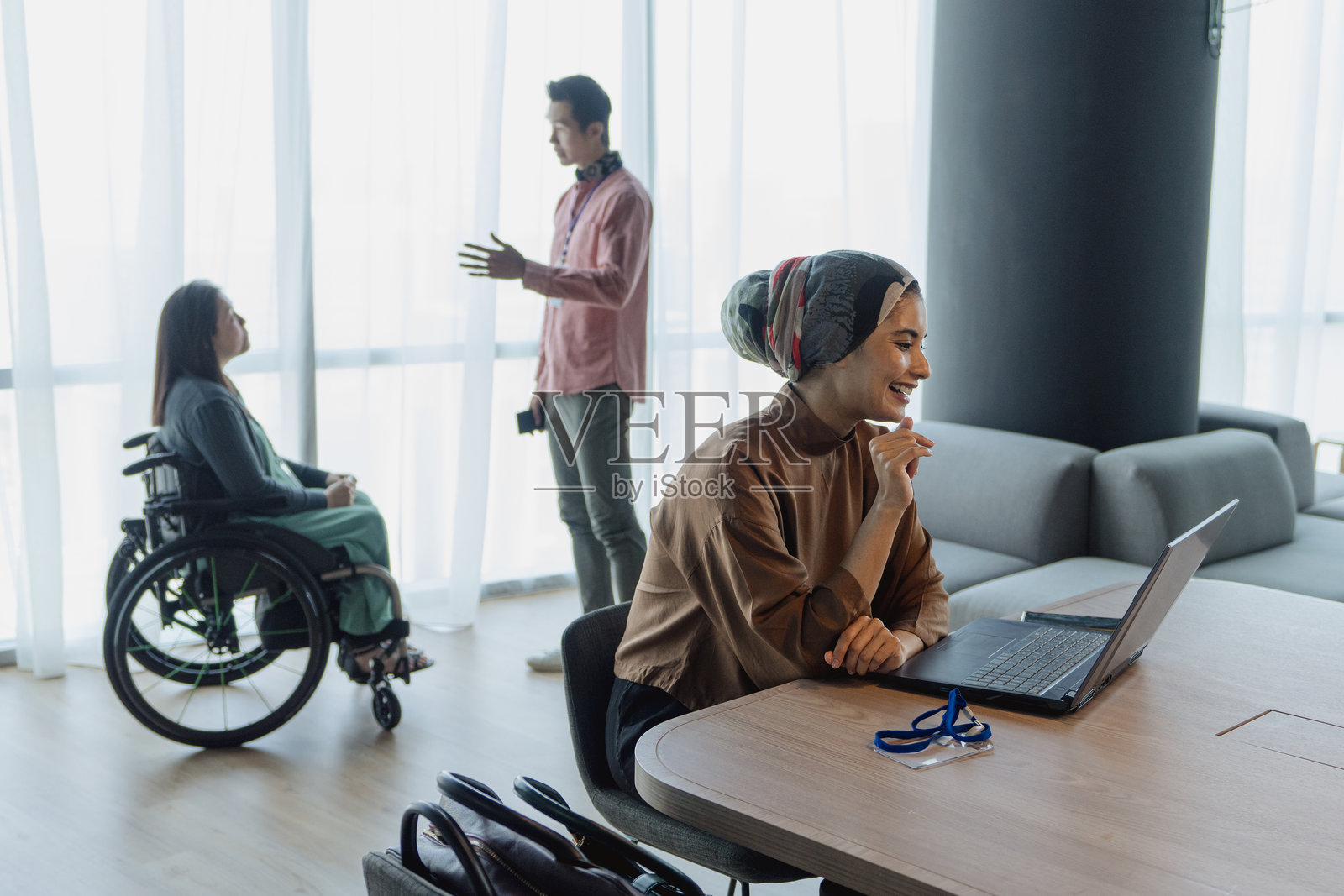 一位穆斯林高管在包容的办公环境中使用笔记本电脑工作照片摄影图片