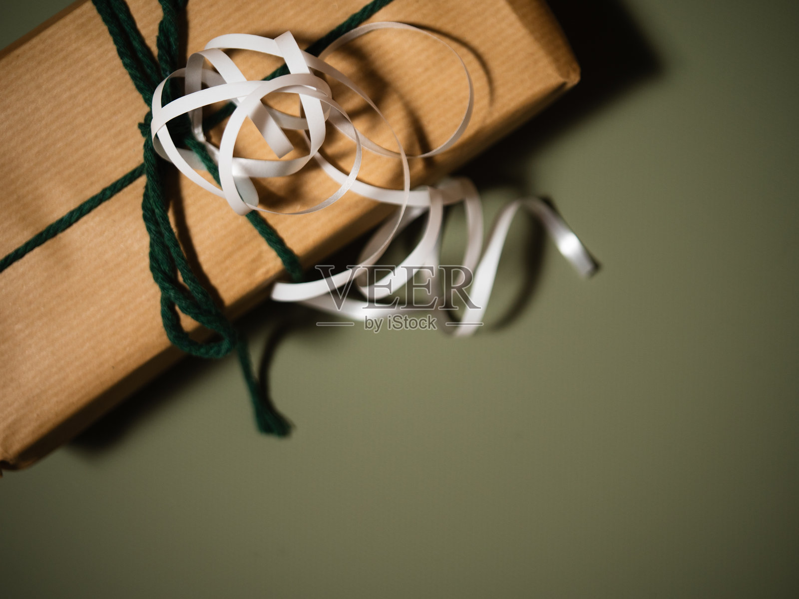 圣诞礼物，带有包装丝带和细绳，绿色背景照片摄影图片