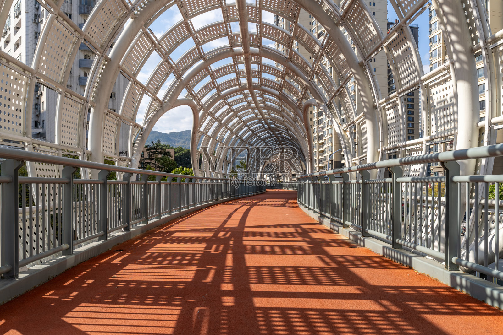 圆形镂空天桥顶棚与红色沥青路照片摄影图片
