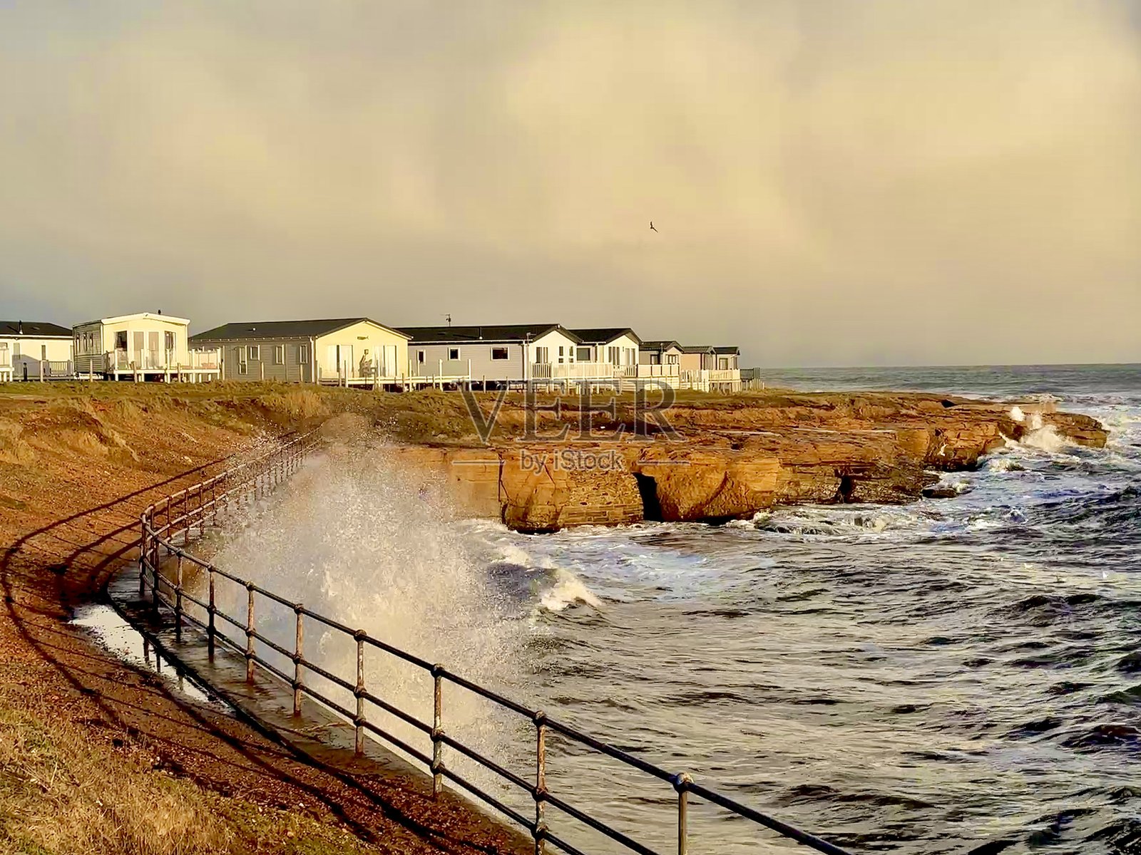 海浪拍打着诺森伯兰郡海滨新比金的防波堤照片摄影图片