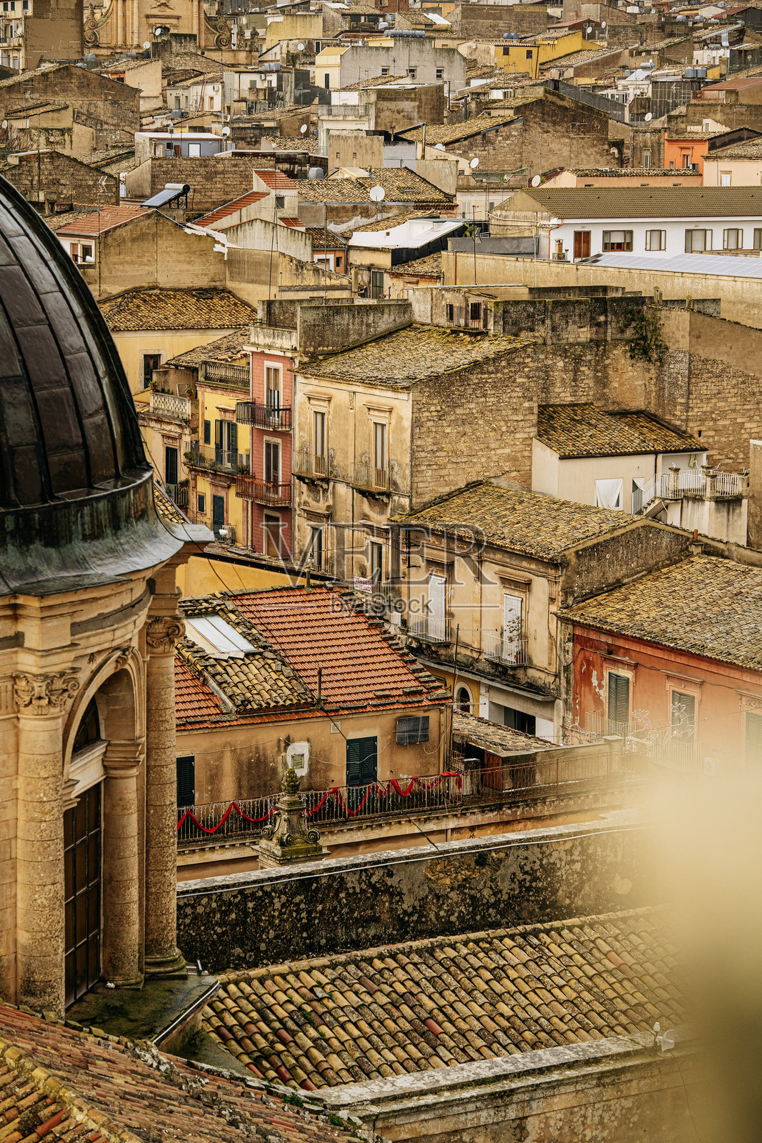 从圣乔瓦尼·巴蒂斯塔大教堂俯瞰拉古萨的全景：历史悠久的西西里城市屋顶、教堂圆顶以及阴天下的密集石砌建筑照片摄影图片