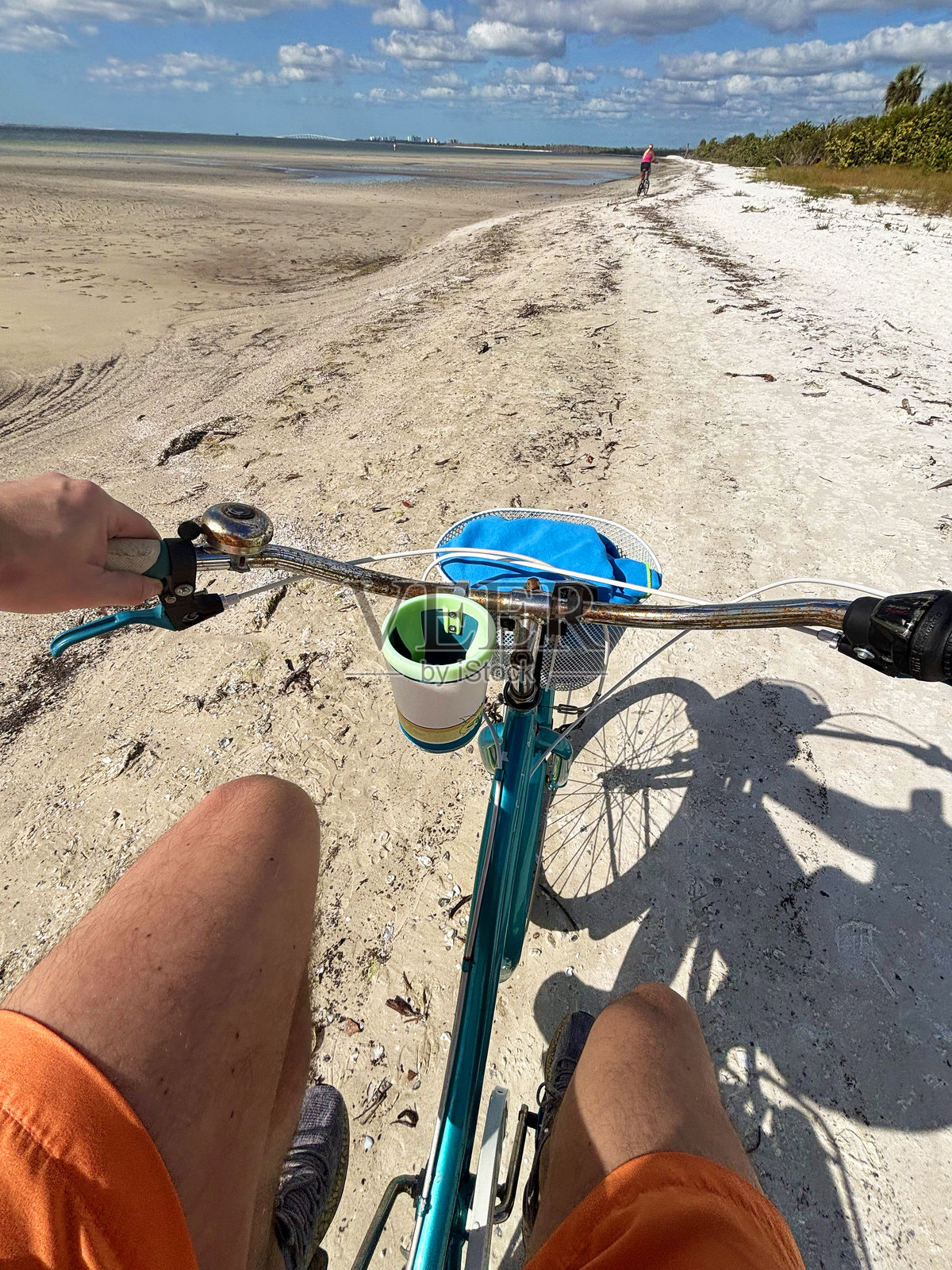 POV，拉丁裔游客男性和他的伴侣在佛罗里达州迈阿密的海滩上骑自行车，眺望大海。照片摄影图片