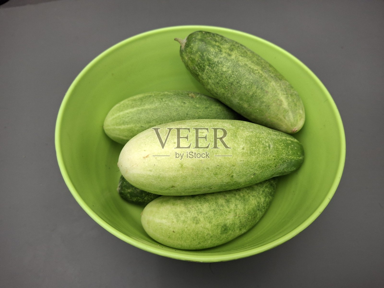绿色碗里盛放着黄瓜（Cucumis sativus）。照片摄影图片