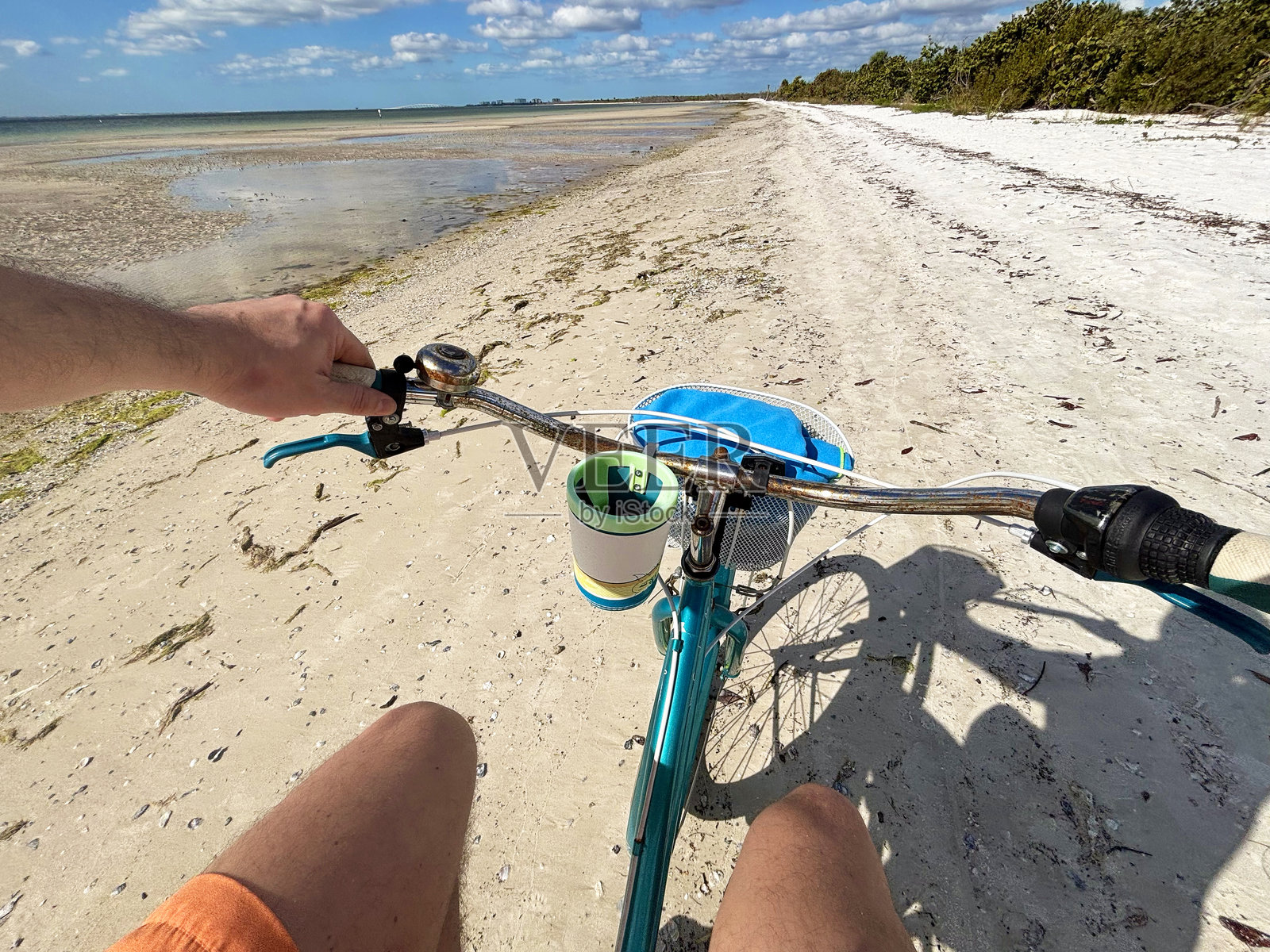 一名拉丁裔男性游客骑自行车在迈阿密海滩上，面朝大海照片摄影图片