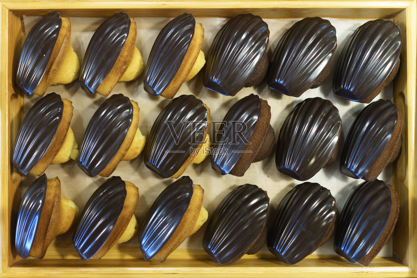 木盘中摆放的巧克力釉面玛德琳蛋糕照片摄影图片