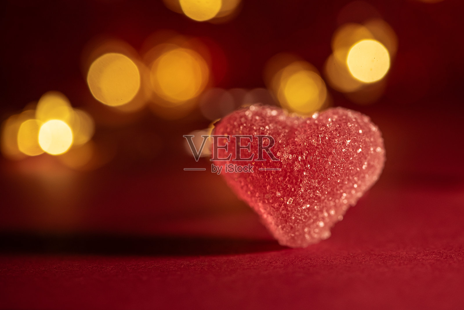 红色背景上的粉色糖心与散景灯光。情人节庆祝活动照片摄影图片