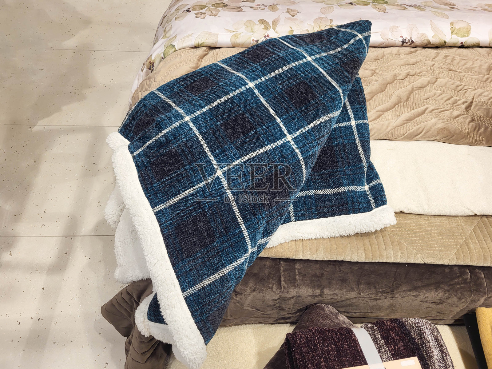 一条格子毛毯，带有毛绒内衬，随意地铺在床上照片摄影图片