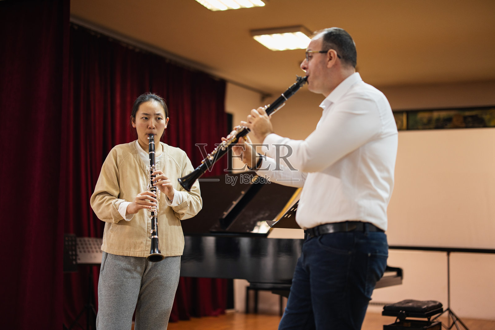 女音乐生在导师指导下练习单簧管照片摄影图片