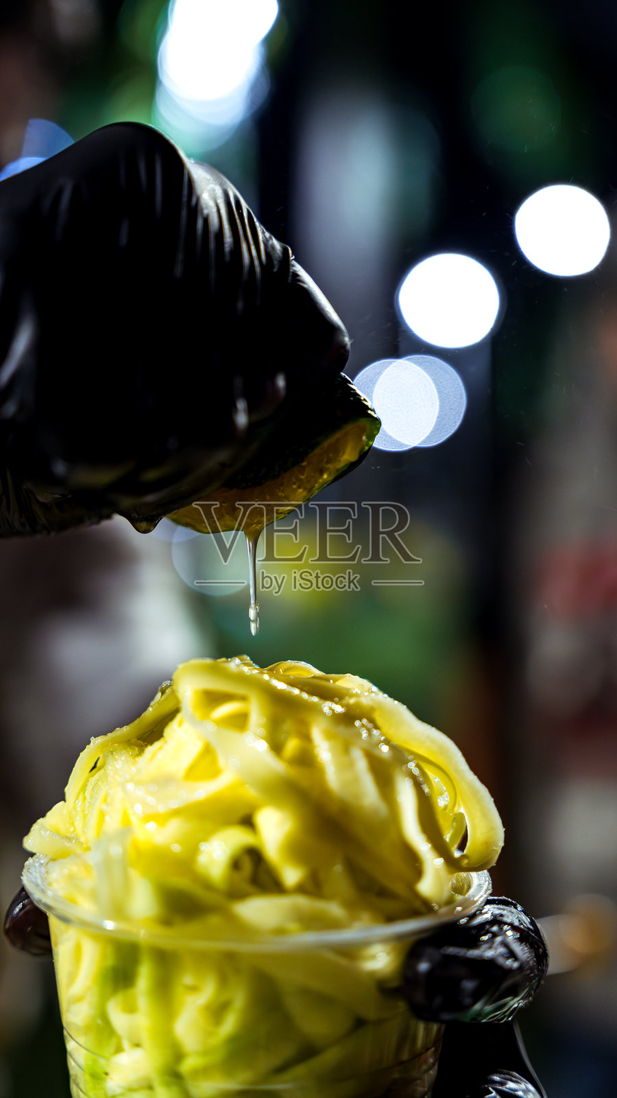 手挤柠檬汁淋在新鲜芒果街头小吃上照片摄影图片