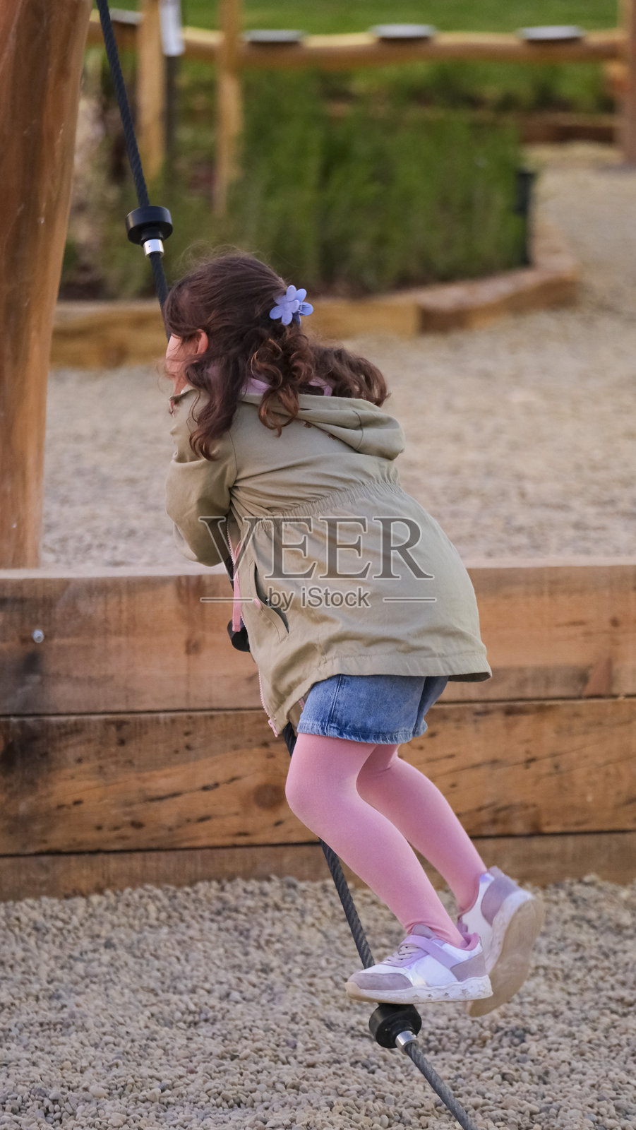 可爱的小女孩在公园的儿童游乐场玩耍，非常开心照片摄影图片