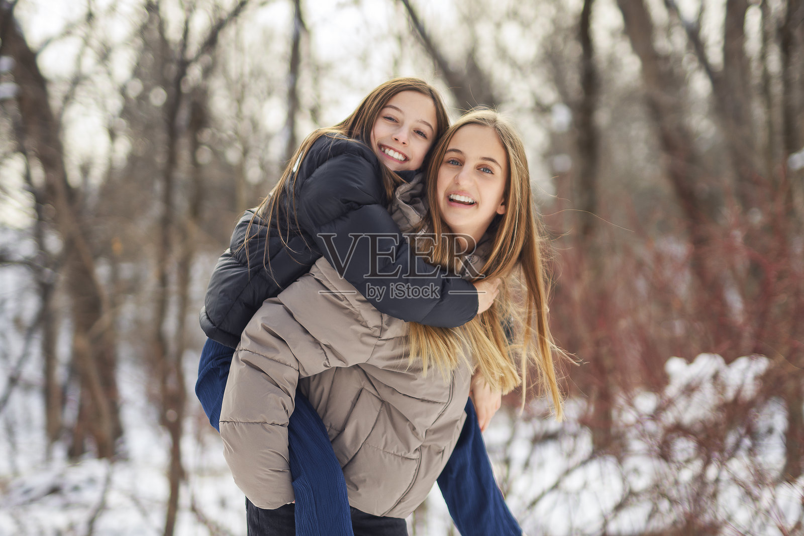 寒冷冬日，两位朋友在户外。照片摄影图片