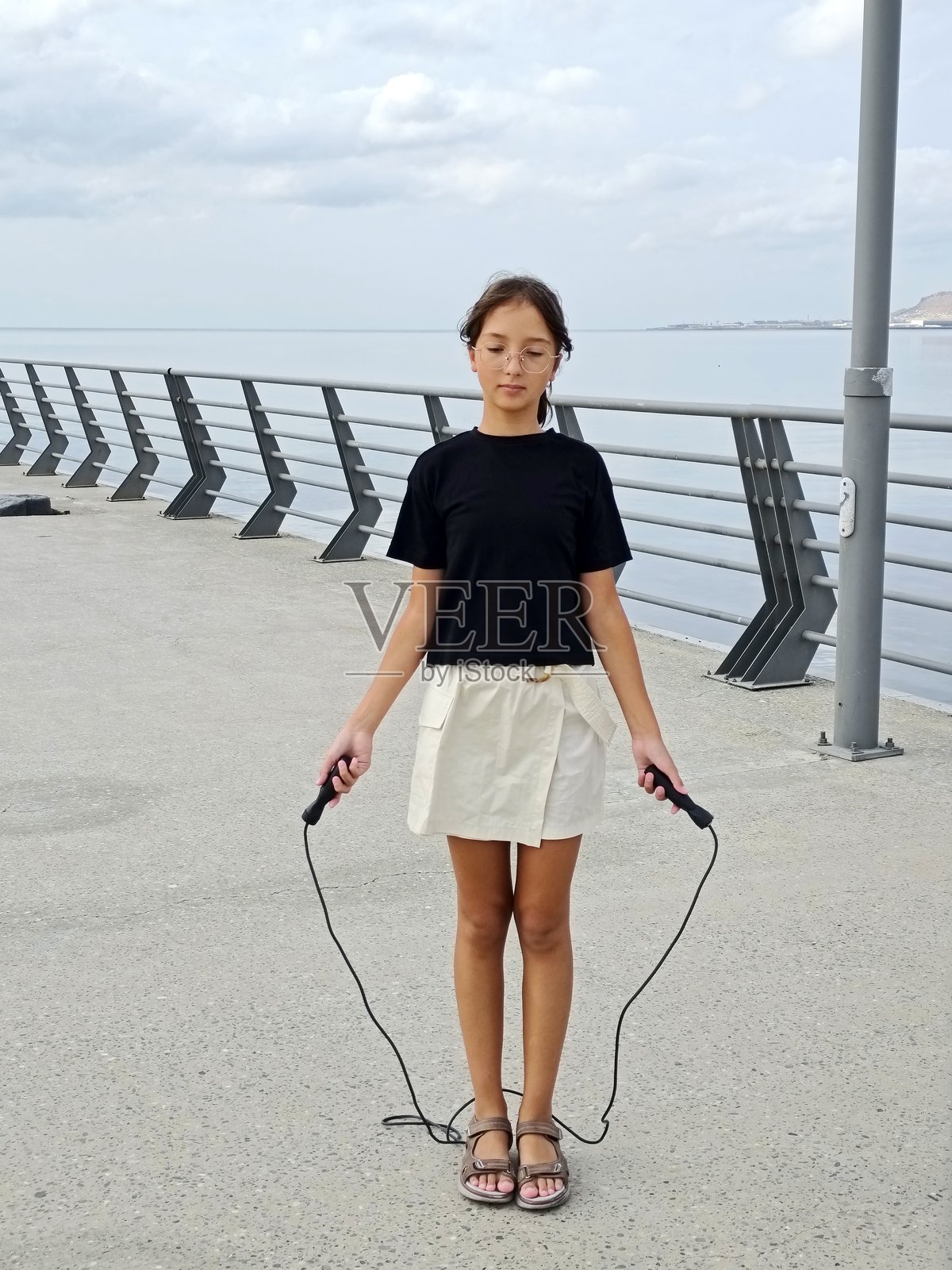 少女在海边跳绳照片摄影图片